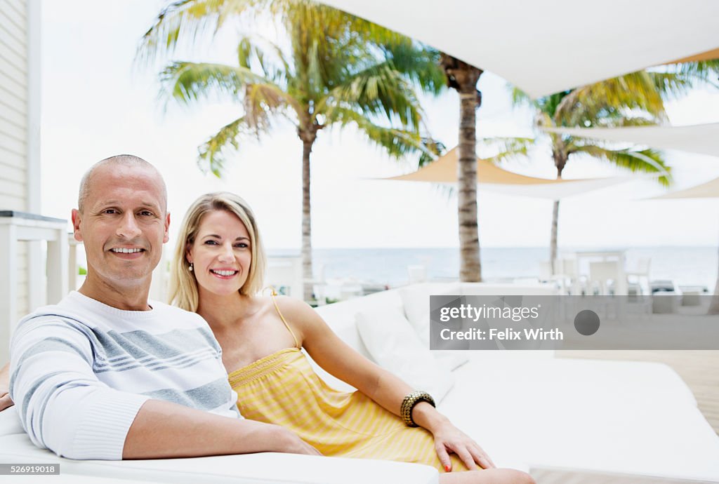 Portrait of man and woman relaxing at cafe nearby beach