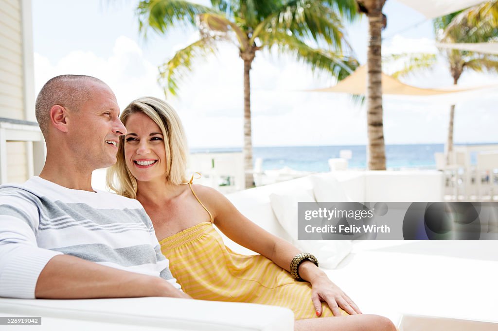 Portrait of man and woman relaxing at cafe nearby beach