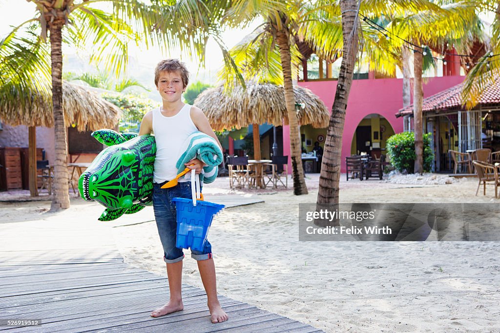 Boy (10-12) posing with beach toys