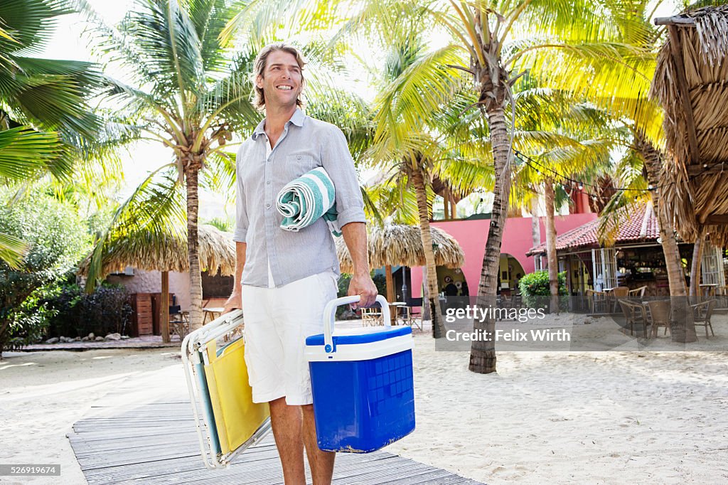 Portrait of young man holding beach equipment
