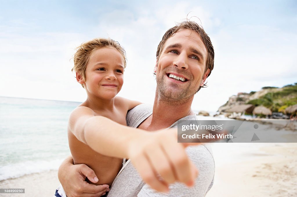 Father holding his son (4-5) on beach