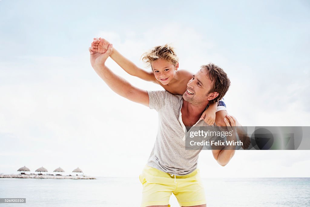 Father carrying his son (4-5) on shoulder