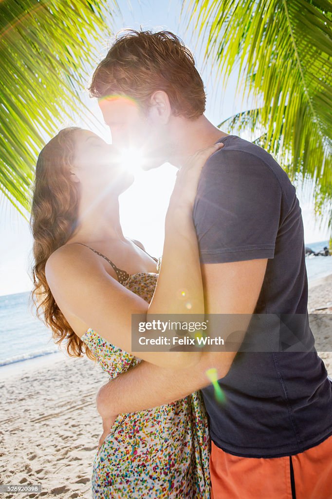 Couple kissing in summer sunlight