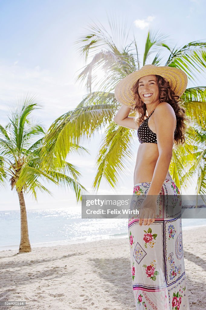 Woman in straw hat relaxing on beach