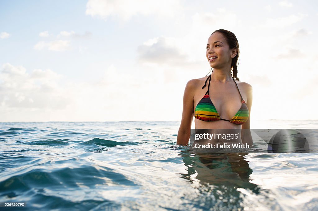 Young woman wading in water on tropical beach
