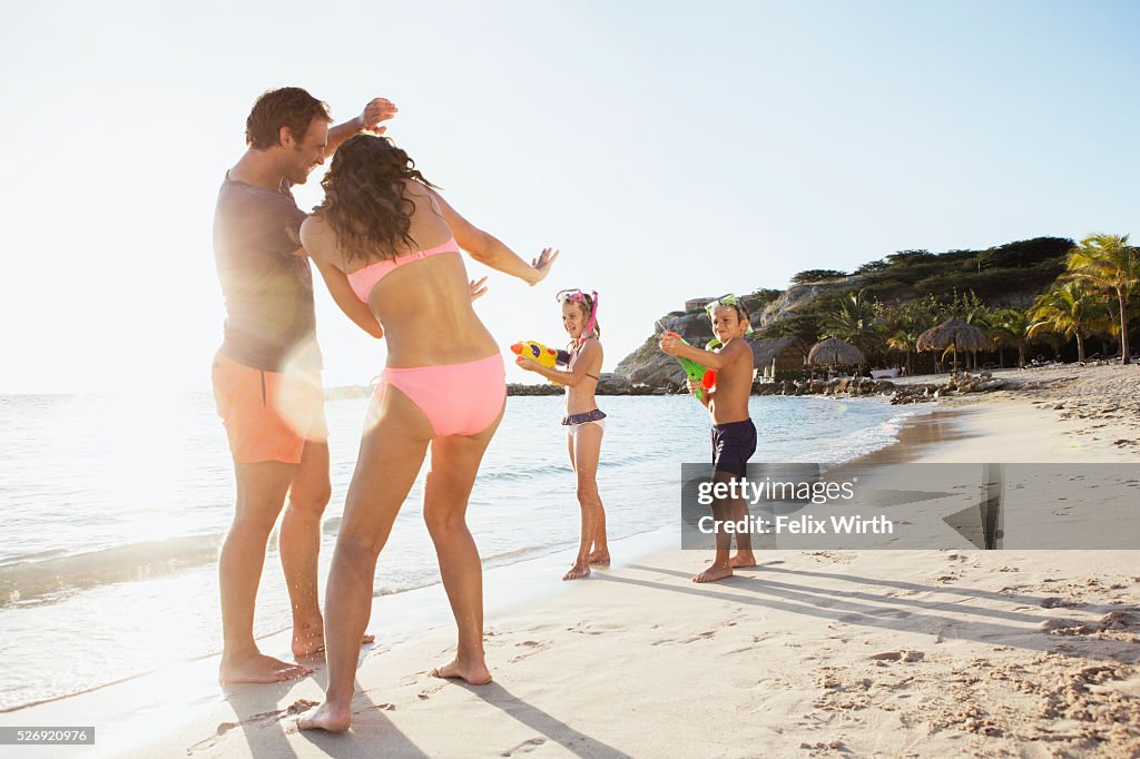 Family with son (8-9) and daughter (10-11) playing on beach