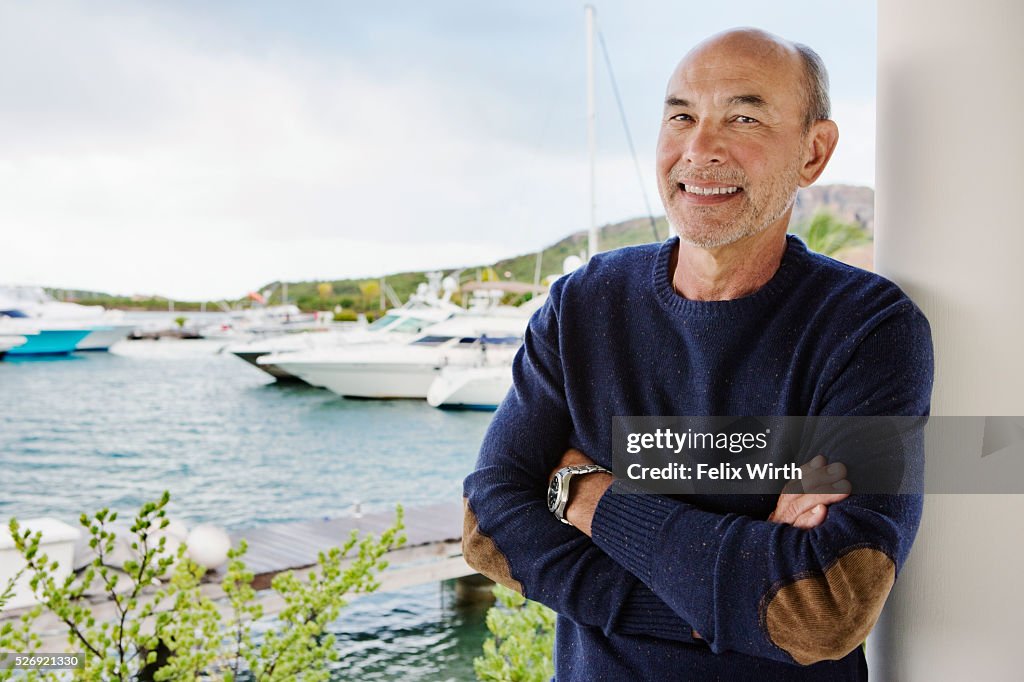 Portrait of senior man posing in front of marina