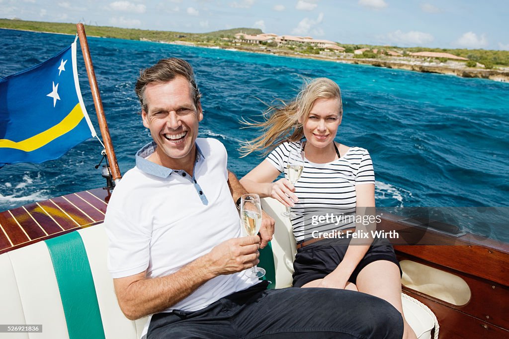 Couple drinking champagne on motorboat