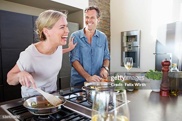 middle-aged couple cooking together - middle aged couple cooking ストックフォトと画像