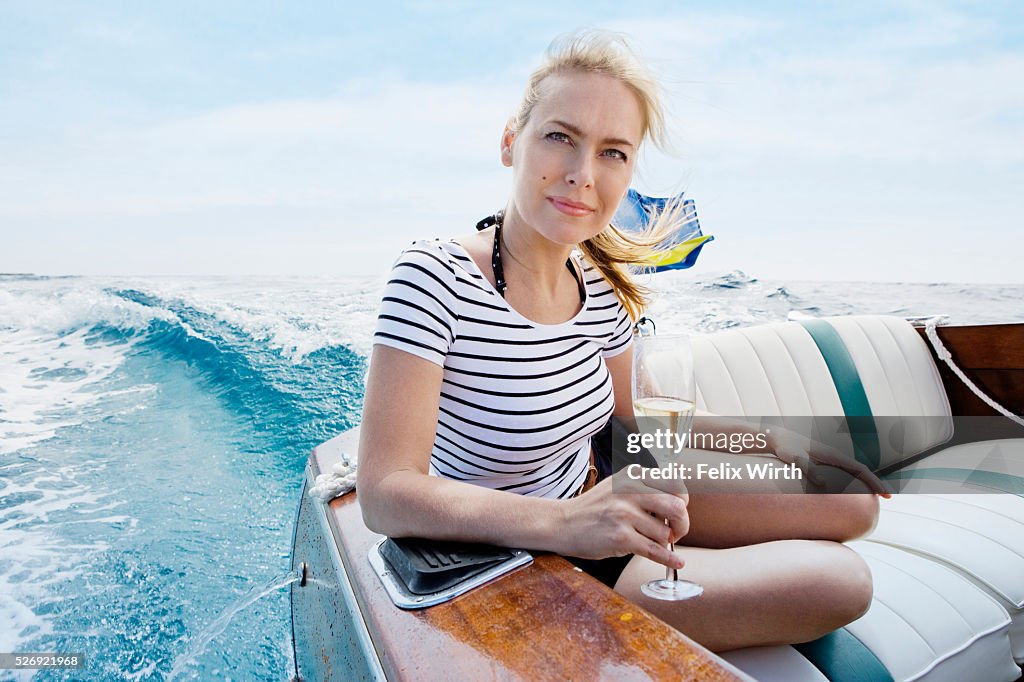 Woman drinking champagne on motorboat