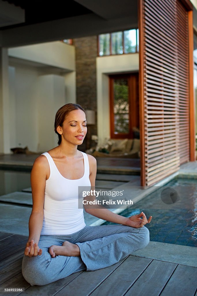 Young woman doing yoga on patio