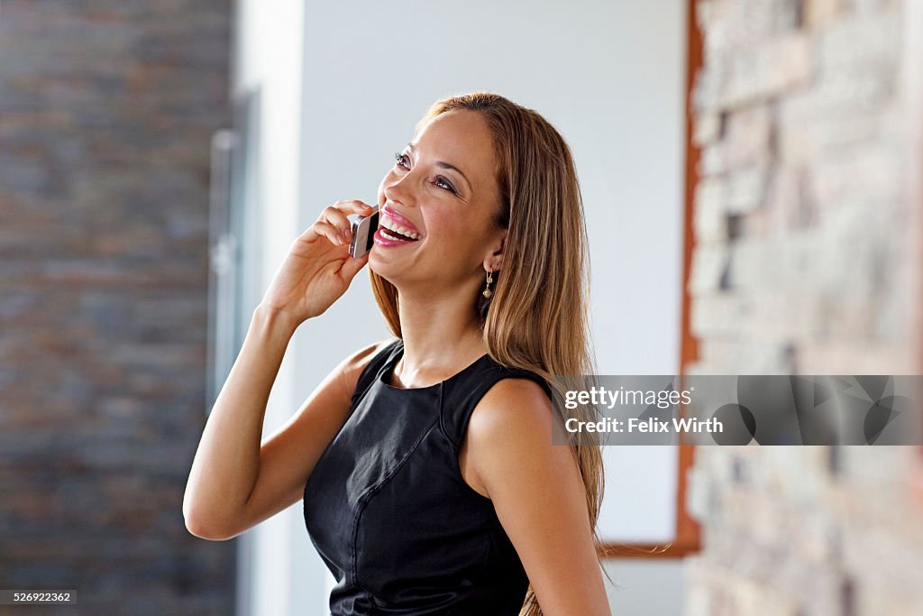 Young woman talking on phone at home