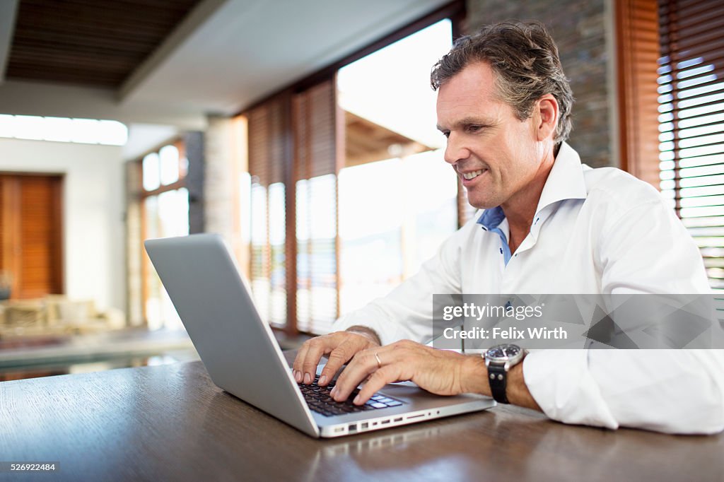 Middle-aged man using laptop at home