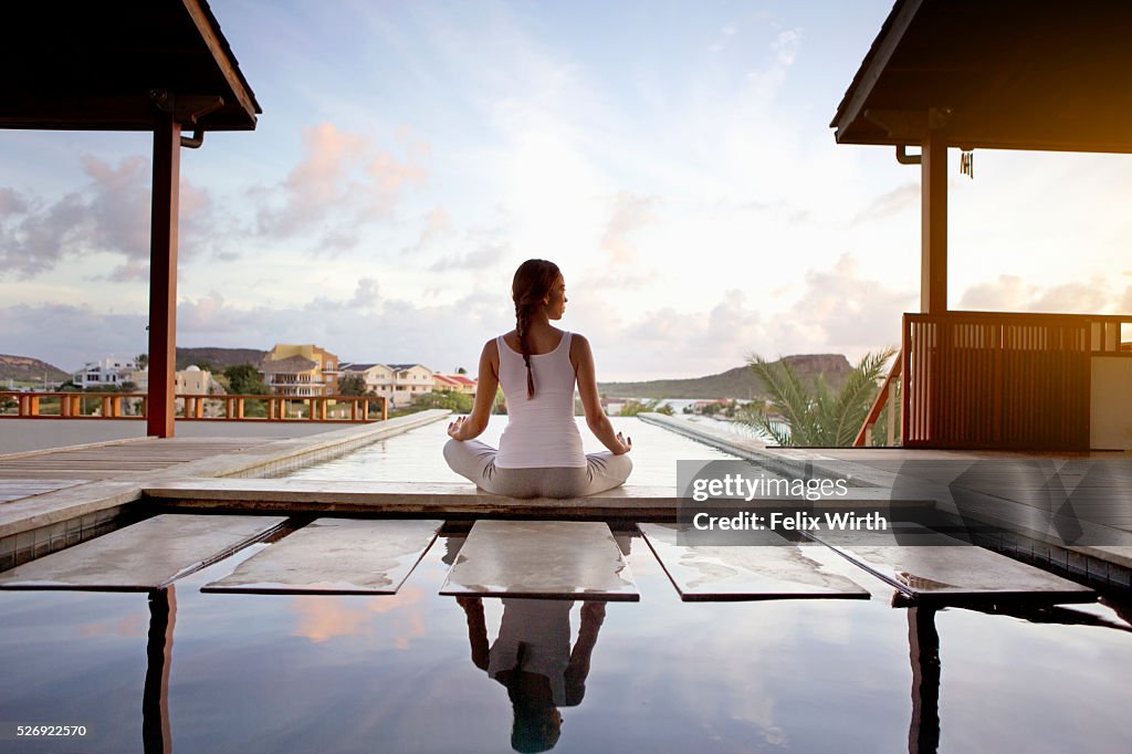 Young woman doing yoga on patio