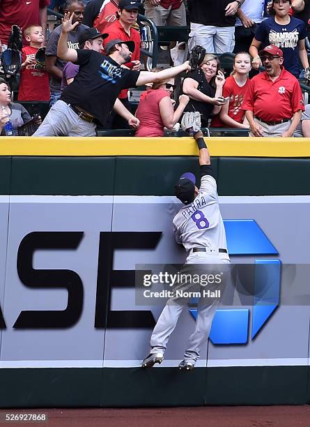 Gerardo Parra of the Colorado Rockies attempts to make a leaping catch at the right field wall on a first inning home run by Brandon Drury of the...