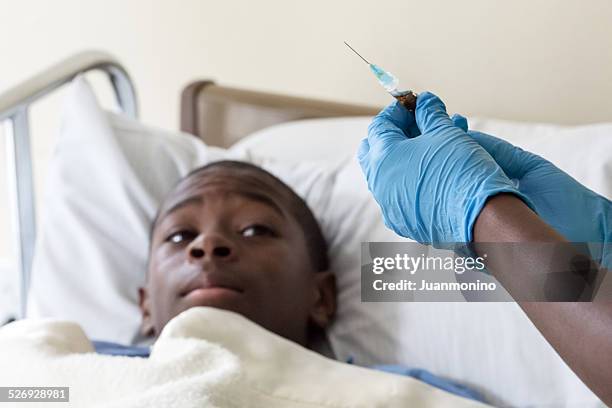 teenage boy awaits shot from doctor - ebola hospital stock pictures, royalty-free photos & images