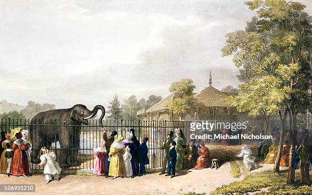Visitors to the London Zoological Gardens in Regent's Park. The Victorian illustration shows an animal house in the Strawberry Hill style, an...