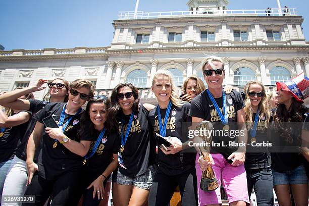 Women's National Soccer Team player Abby Wambach, holds the FIFA World Cup Champions Trophy with other players, Christine Rampone, Carli Lloyd and...