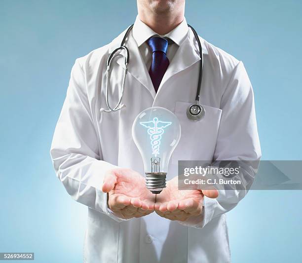 doctor with bulb floating over palms - hands cupped stock pictures, royalty-free photos & images