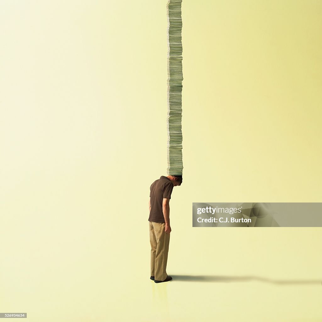 Man carrying stack of currency on head