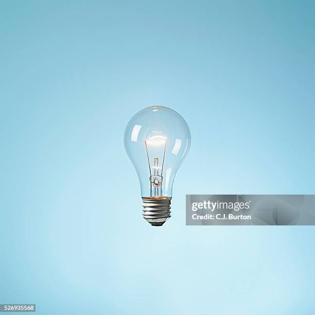 illuminated lightbulb - lightbulb floating stock pictures, royalty-free photos & images