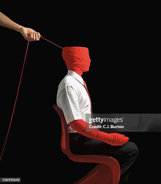 woman unravelling man wrapped in yarn - invisible people stock pictures, royalty-free photos & images