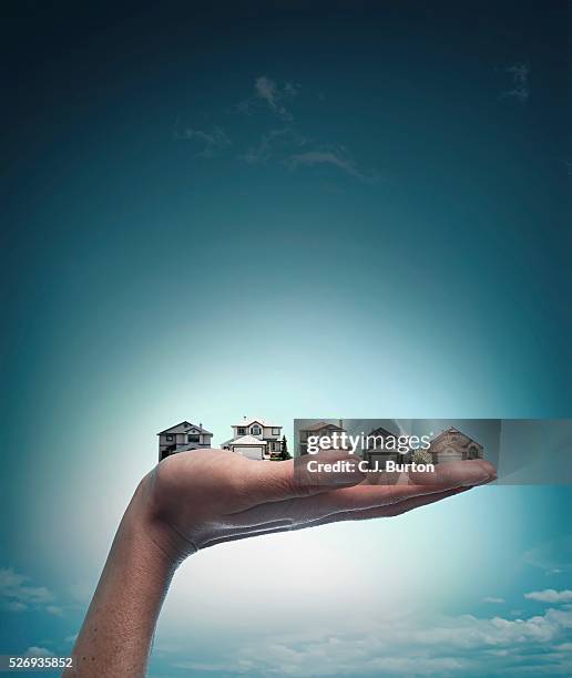 woman's hand holding several houses - micro finance stock pictures, royalty-free photos & images