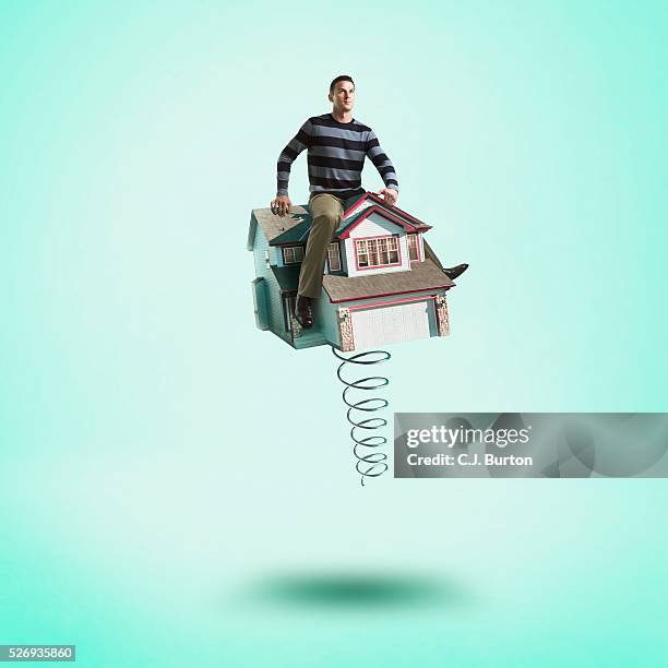 man sitting on top of house that has a giant spring - high resolution stock pictures, royalty-free photos & images
