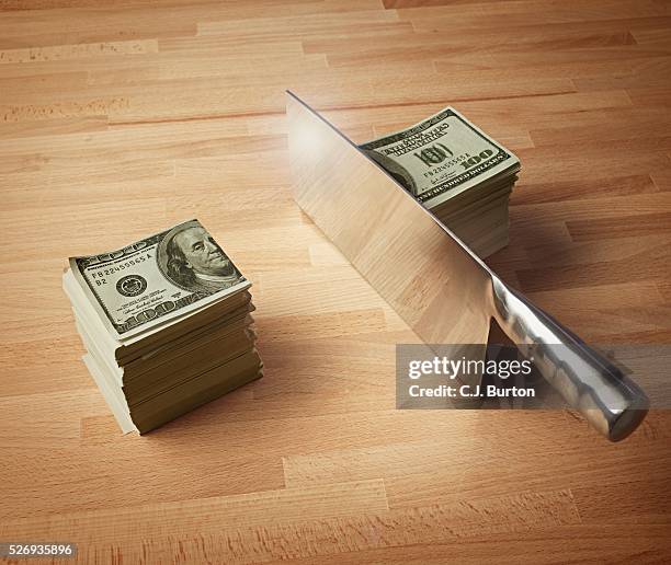 meat cleaver cutting a stack of money in half - meat cleaver stock pictures, royalty-free photos & images