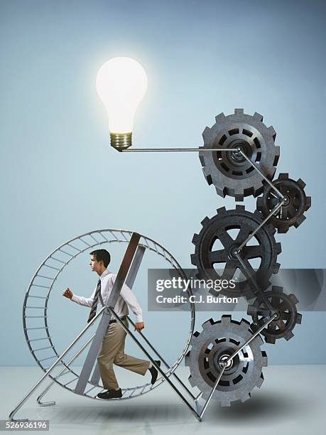 businessman running on exercise wheel - tâche fastidieuse photos et images de collection