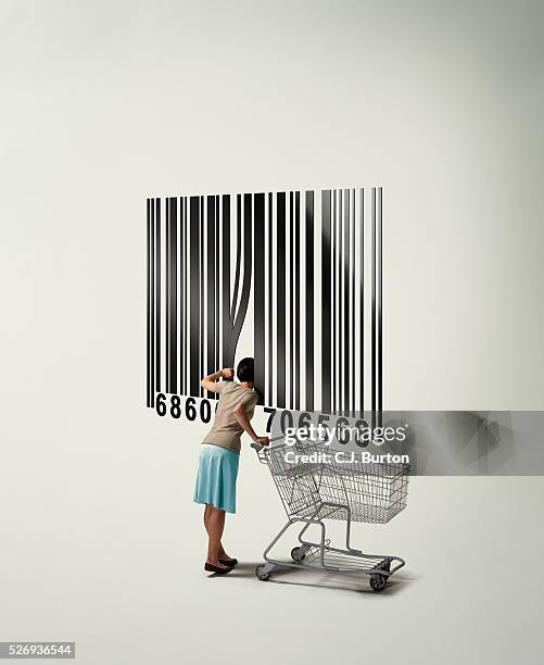 woman with shopping cart looking inside giant barcode - ショッピングカート ストックフォトと画像