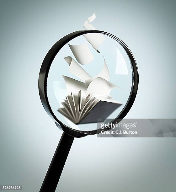 magnifying glass over book - literature stock pictures, royalty-free photos & images