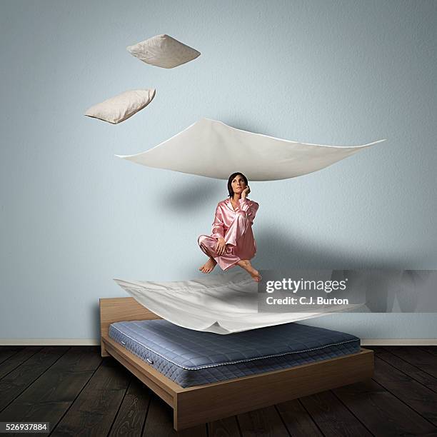 woman levitating over bed - man sleeping pillow stock-fotos und bilder