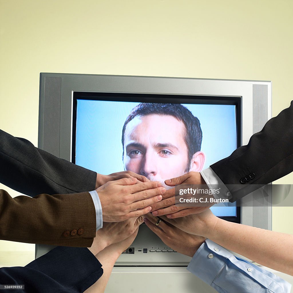 Hands covering mouth of man displayed on tv