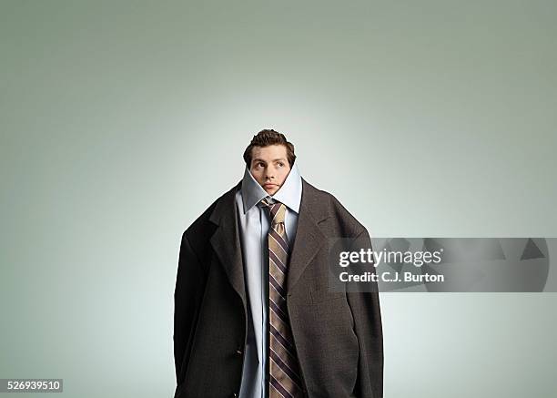 man wearing oversized suit - larger than life stock pictures, royalty-free photos & images