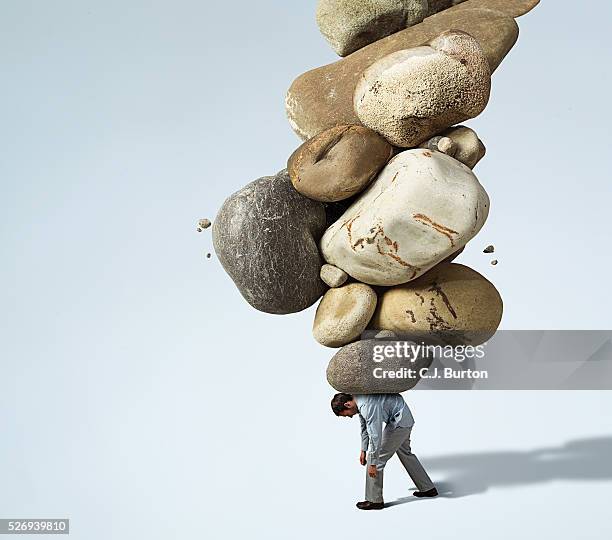 man with stack of rocks on his back - sinnlosigkeit stock-fotos und bilder