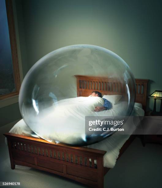 man sleeping in bed surrounded by bubble - people inside bubbles fotografías e imágenes de stock