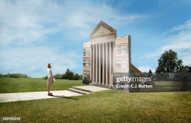 female college student stands in front of flat facade of college building - artificiel photos et images de collection
