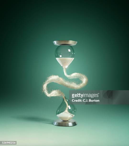 hour glass with floating sand - hourglass stock pictures, royalty-free photos & images
