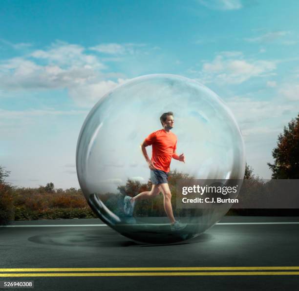 man jogging surrounded by bubble - protection stockfoto's en -beelden