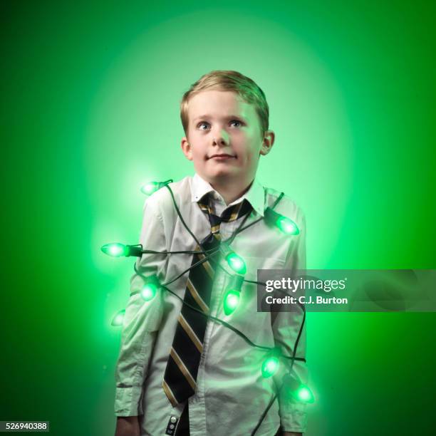 boy wrapped in green christmas lights - tangled christmas lights stock-fotos und bilder