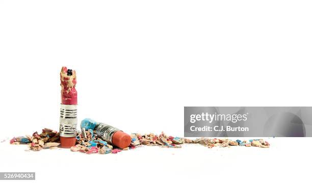 two colored pencils bitten down to small bits on white background - chewing gum stockfoto's en -beelden