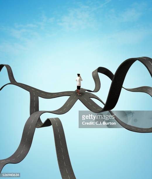 woman in white coat stands in middle of several crossroads floating in sky - choice stockfoto's en -beelden