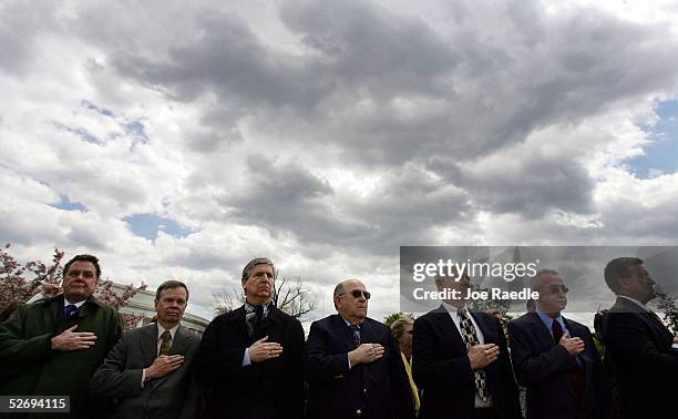 Former Iranian hostages Michael Howland, Steven Lauterbach, John Limbert, Richard Morefield, Paul Needham and Regis Ragan place their hands over...