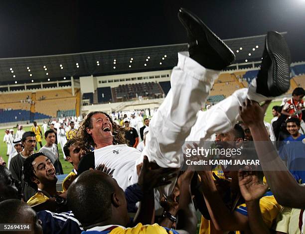 Franch coach Bruno Metsu of Al-Gharrafa club jubilates with his players after winning the Qatari national soccer league tournament with 60 points in...