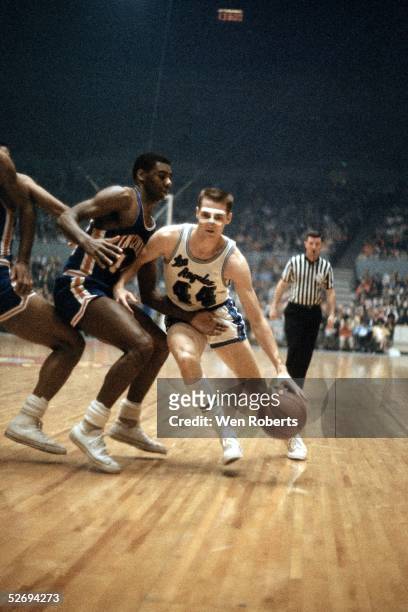Jerry West of the Los Angeles Lakers dribble drives against the Cincinnati Royals during the NBA game at the Los Angeles Sports Arena circa 1960's in...
