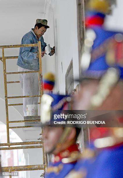 Un empleado de mantenimiento pinta la pared del corredor principal de entrada al palacio de Carondelet, sede del gobierno en Quito el 25 de abril de...