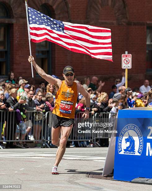 Donny Sazama, Hermantown, Minnesota, carries American flag high as he turns corner into the Boylston Street homestretch with quarter mile to go