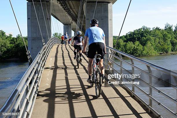 biking on bridge over james river in richmond - richmond virginia stock pictures, royalty-free photos & images