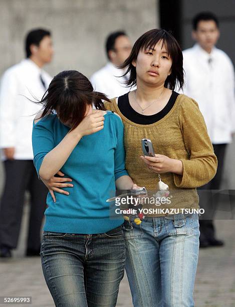 Relatives of a train crash victim leave a gymnasium used as a temporary morgue after they checked the body in Amagasaki, near Osaka, western Japan,...
